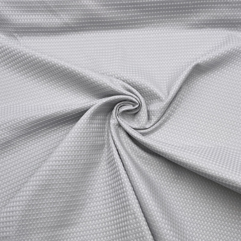 A grey fabric with a waffle-weave texture scrunched in the center in a swirl.  