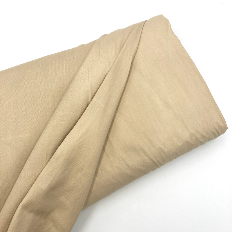 a bolt of tan twill fabric on a white background